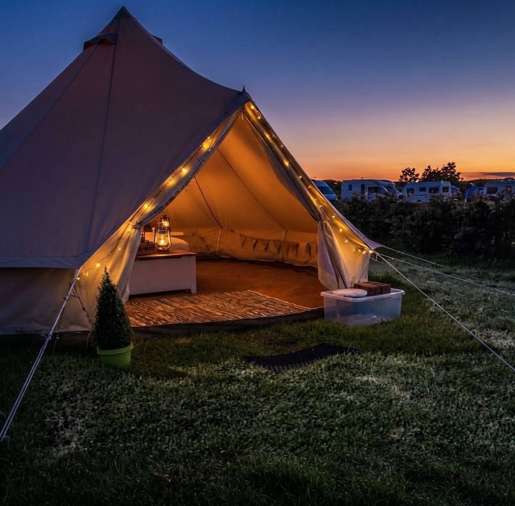 Simple wooden camping pod in a Welsh field with a picnic bench outside