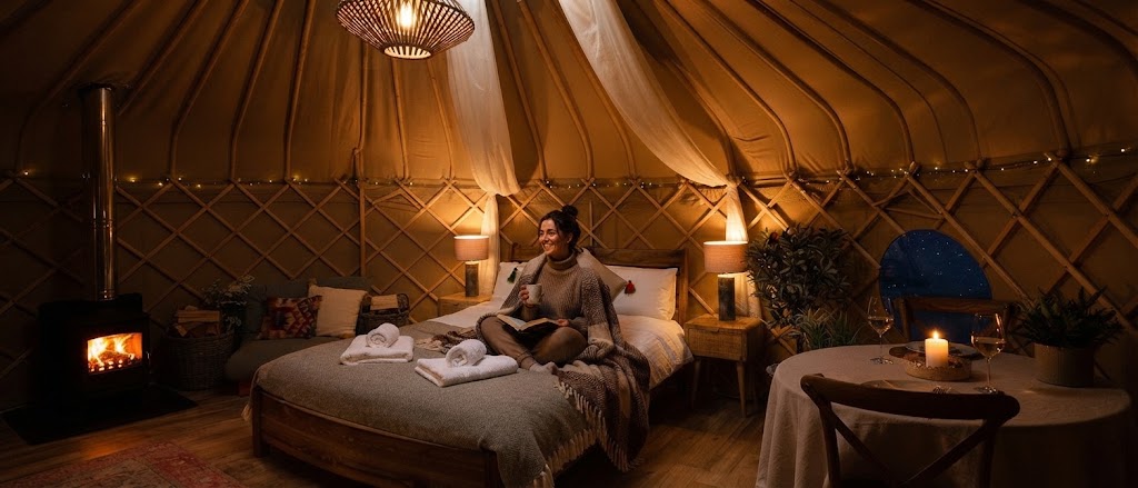 Interior of a luxury safari tent with wood burner, sofa and dining area